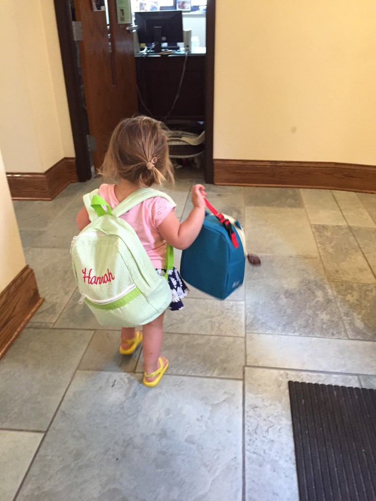 Hannah carrying her backpack and lunchbox at church